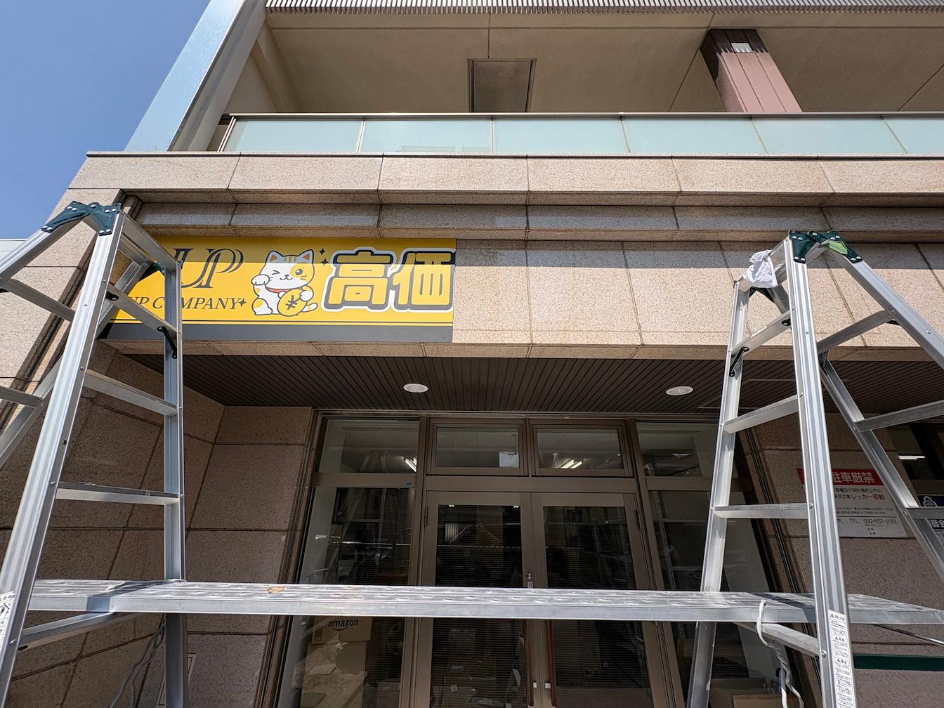 福岡市東区のUP COMPANY合同会社様より、買取専門店舗の店舗名サインおよび買取サービスを案内する壁面看板の製作・施工をご依頼いただきました。3